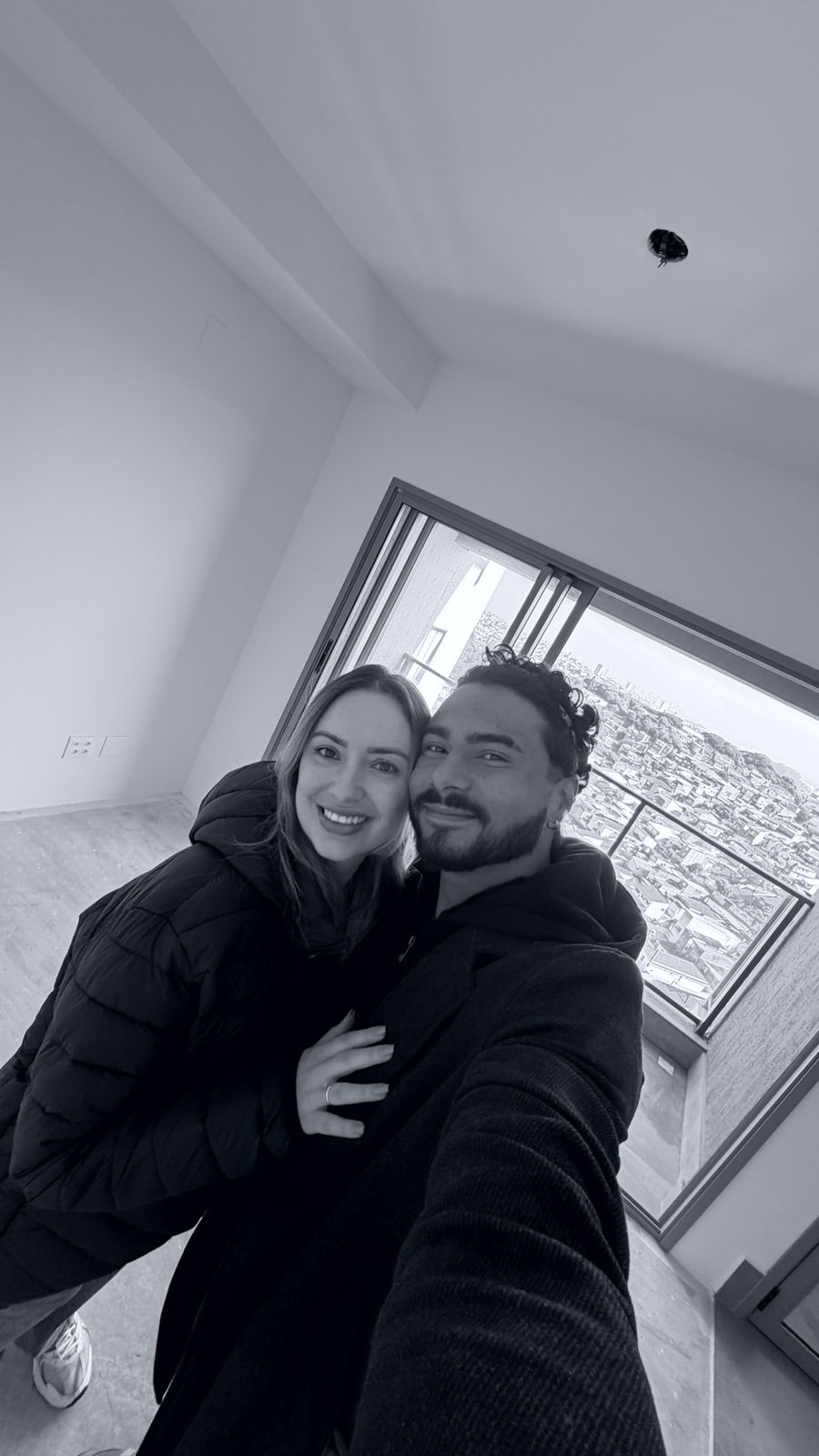 Barbara e Victor no apartamento vazio, a cidade pela janela